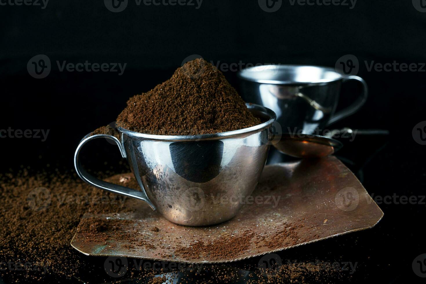 een veel grond koffie binnen een chroom metaal kop foto