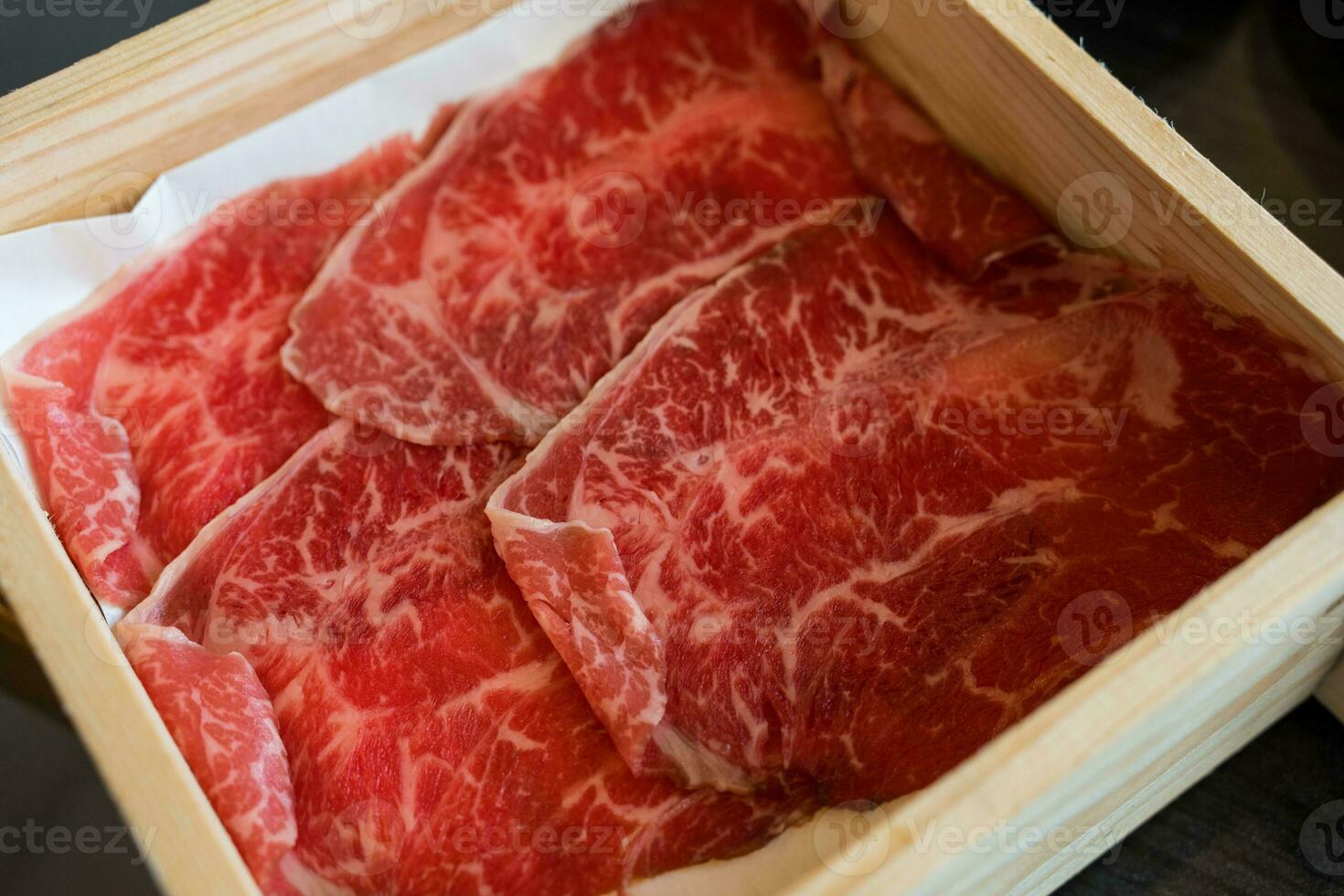 bijzonder gesneden rundvlees met gemarmerd structuur geserveerd Aan hout doos foto