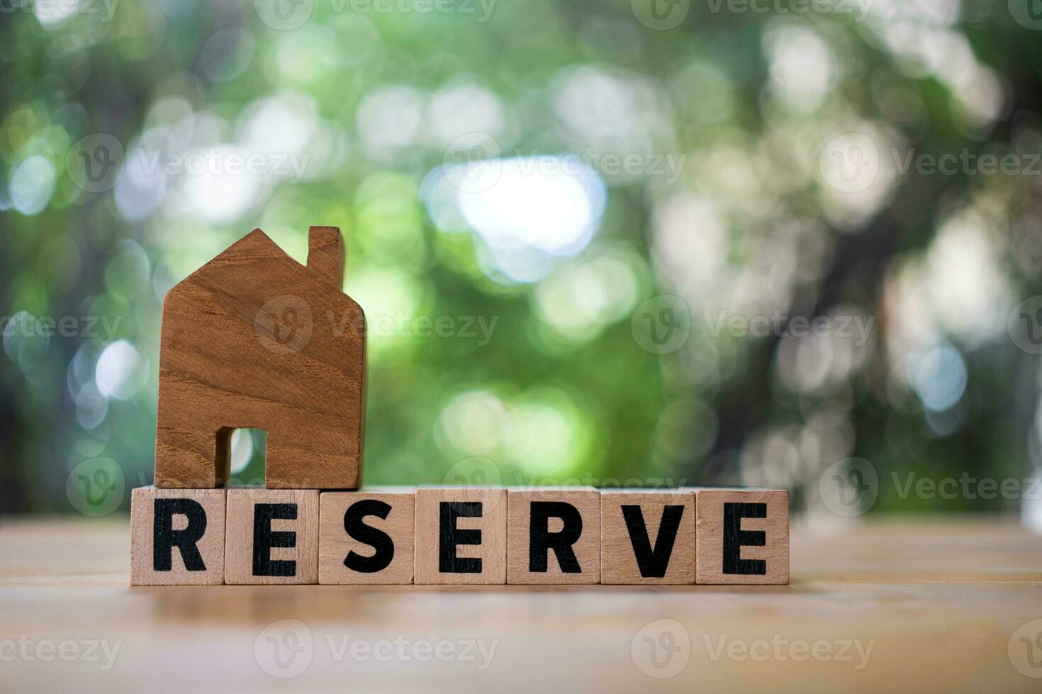 tekst blok van reserveren met huis modellen Aan bovenkant, echt landgoed markt foto