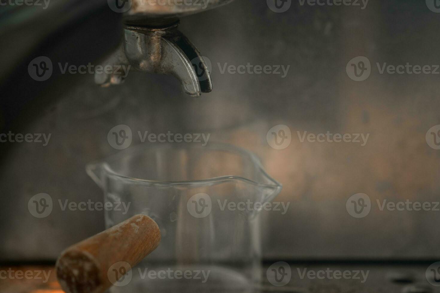 aan het wachten voor een schot van heet espresso koffie is getrokken door een filterhouder foto