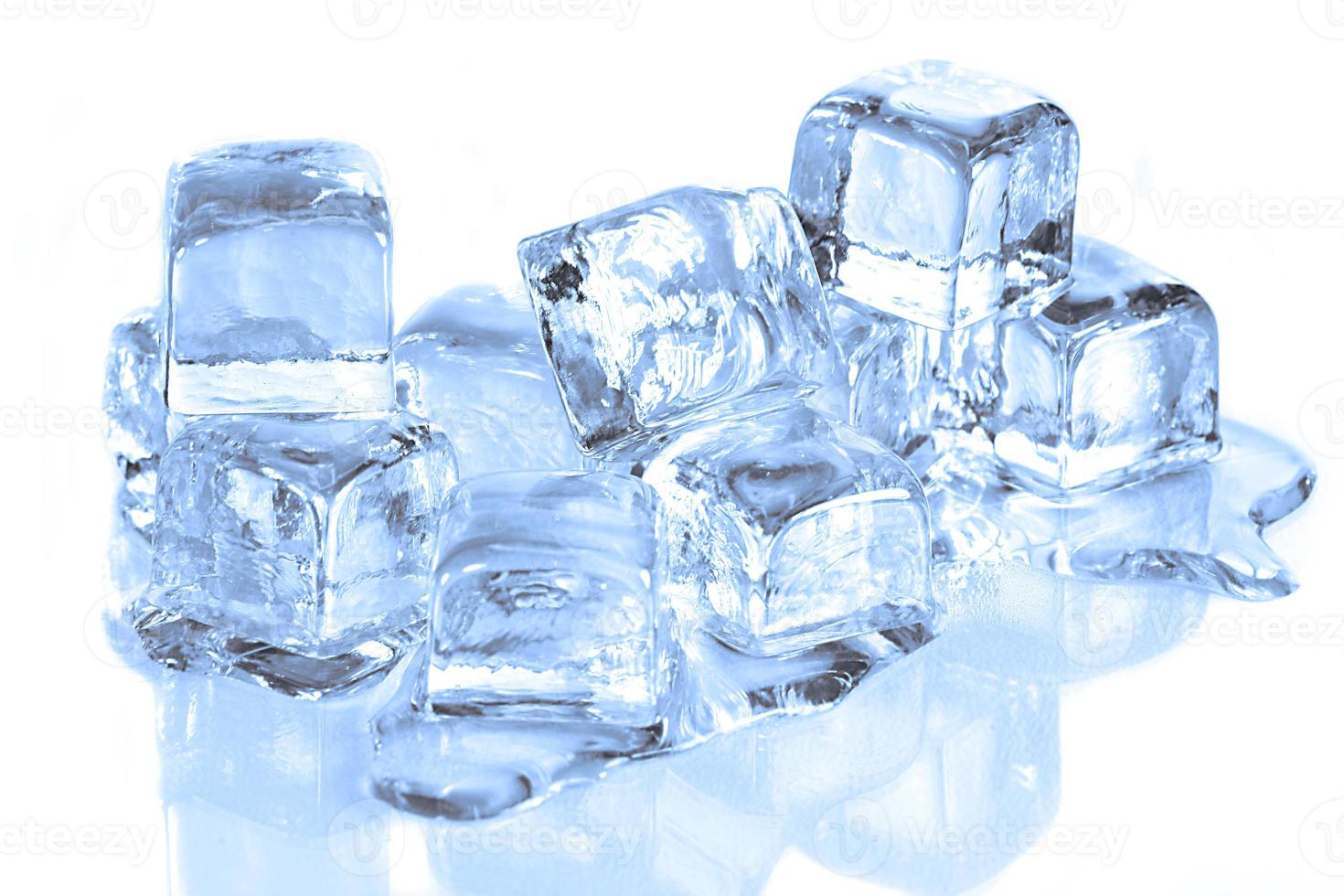 koele ijsblokjes die smelten op een wit reflecterend oppervlak foto