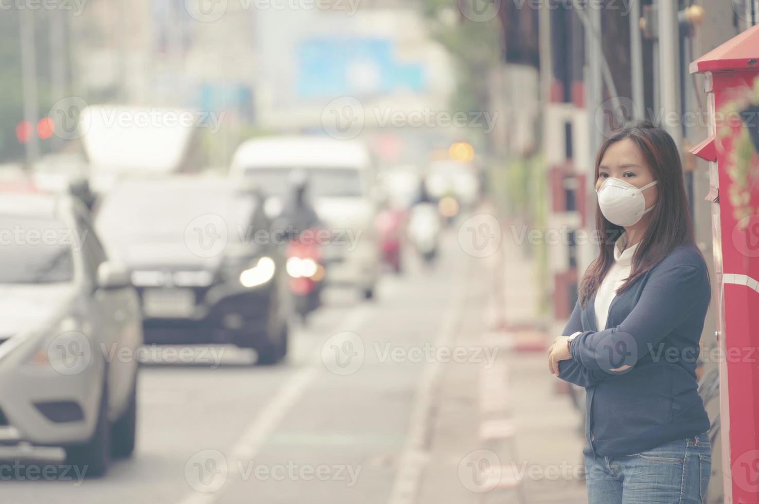 vrouw die beschermend masker draagt in de stadsstraat foto