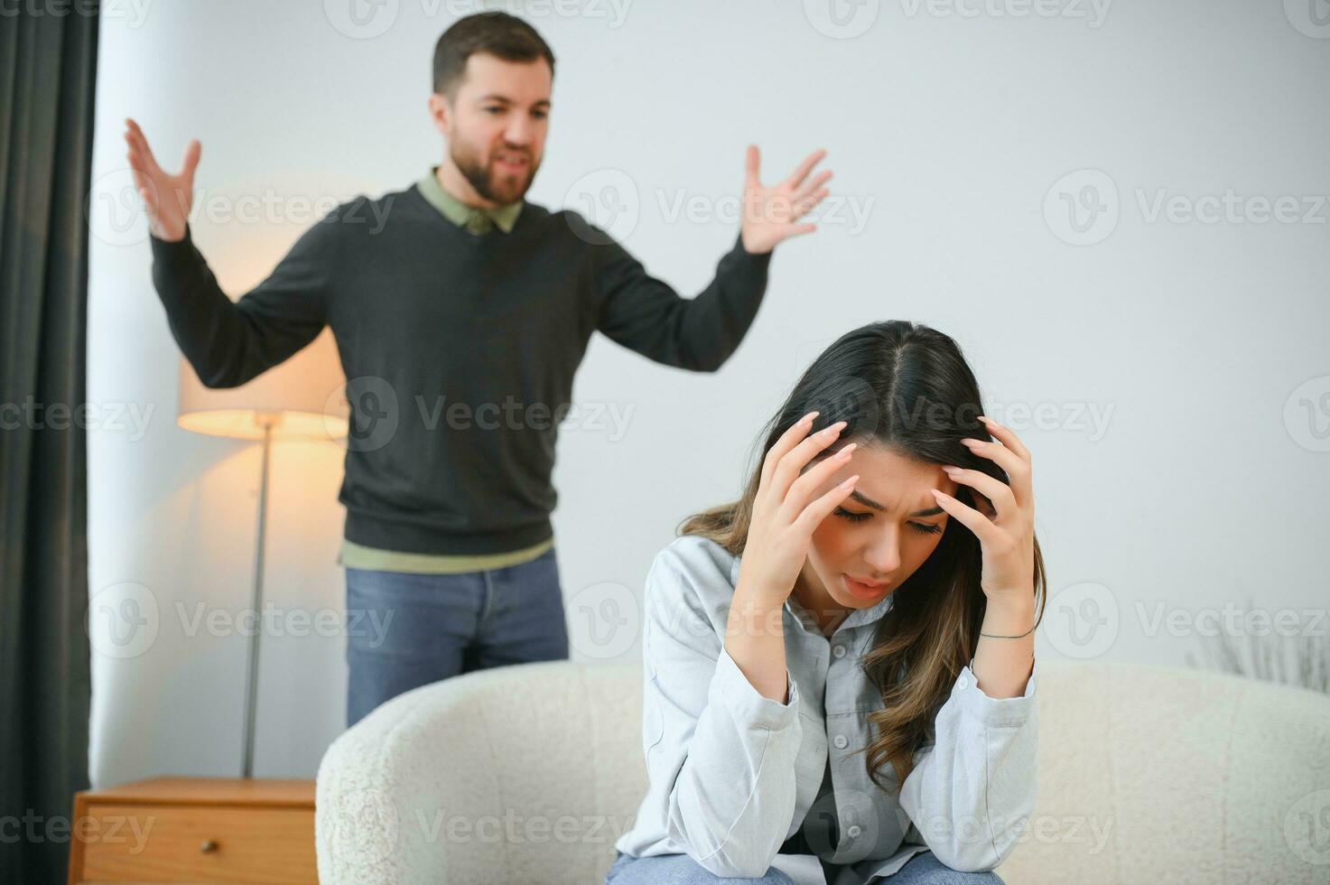 geërgerd man is geschreeuw Bij zijn vrouw met geweld. vrouw is aan het bedekken haar gezicht met angst foto