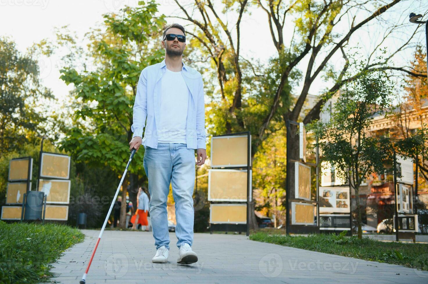 Blind Mens wandelen Aan trottoir Holding stok. foto