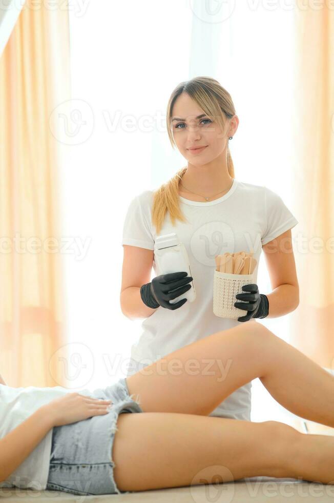 vrouw schoonheidsspecialist Holding stok met was- voor ontharing of suikerhoudend foto