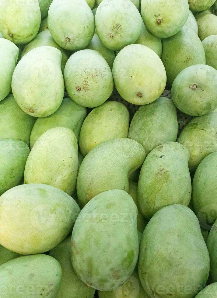 mango fruit achtergrond, stapel van groen dun mango fruit foto