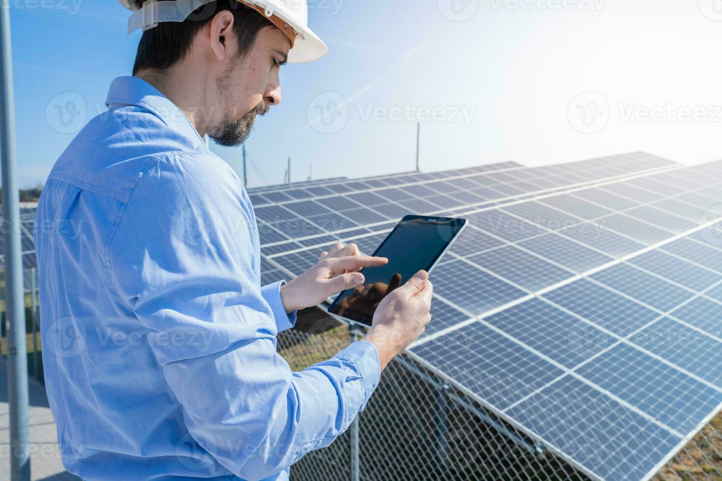 ingenieur werken met een tablet met fotovoltaïsche zonne- paneel systeem fabriek. foto