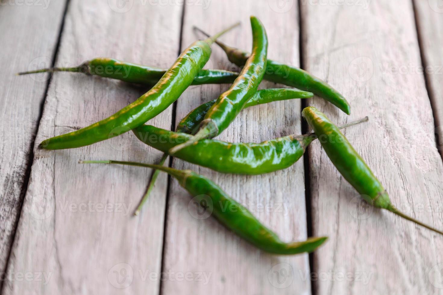 groene rauwe chili op houten achtergrond foto