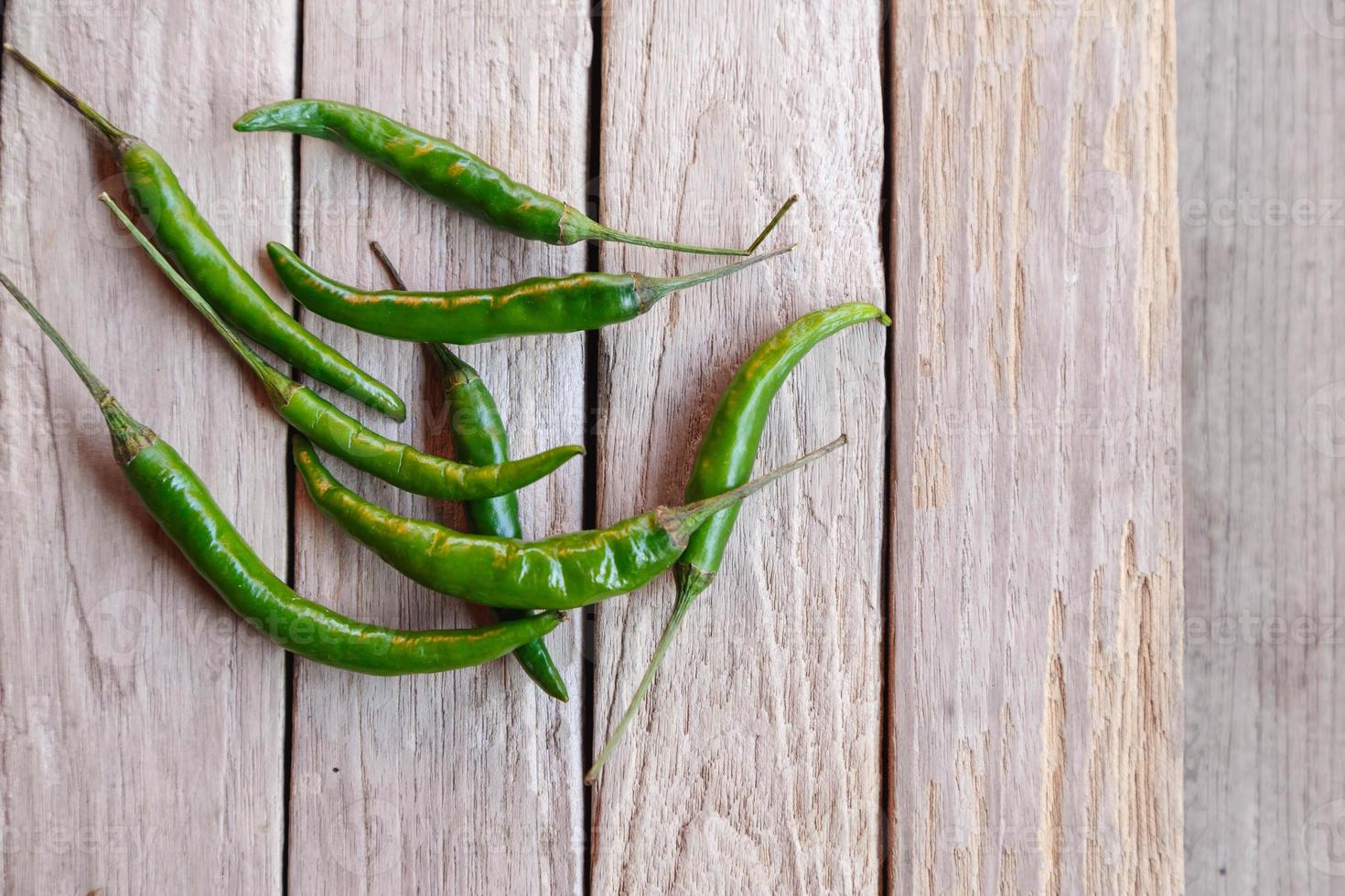 groene rauwe chili op houten achtergrond foto