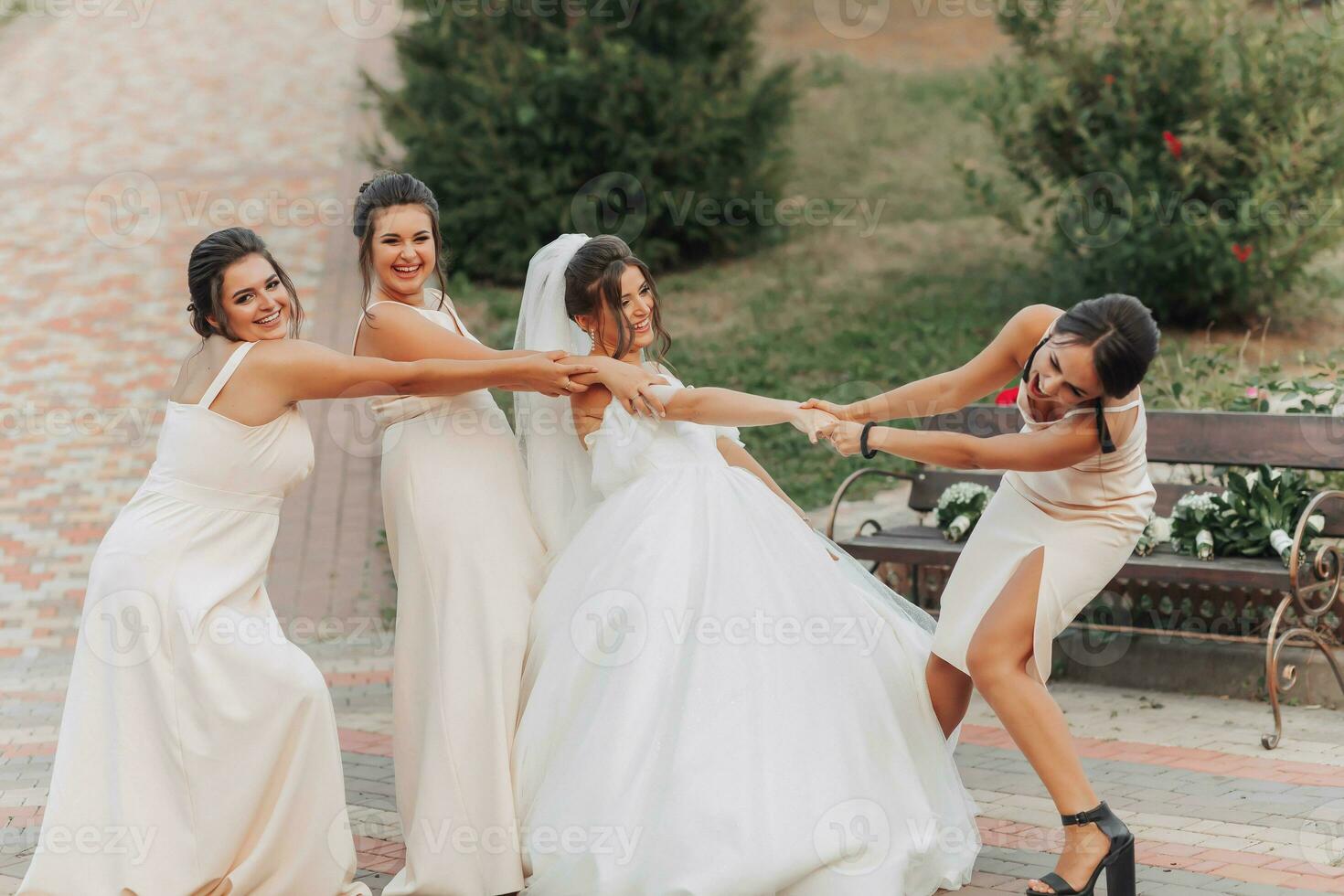 bruiloft foto in natuur. een brunette bruid in een wit lang jurk en haar vriend in een naakt jurk zijn voor de gek houden in de omgeving van samen en glimlachen oprecht. jong Dames. emoties