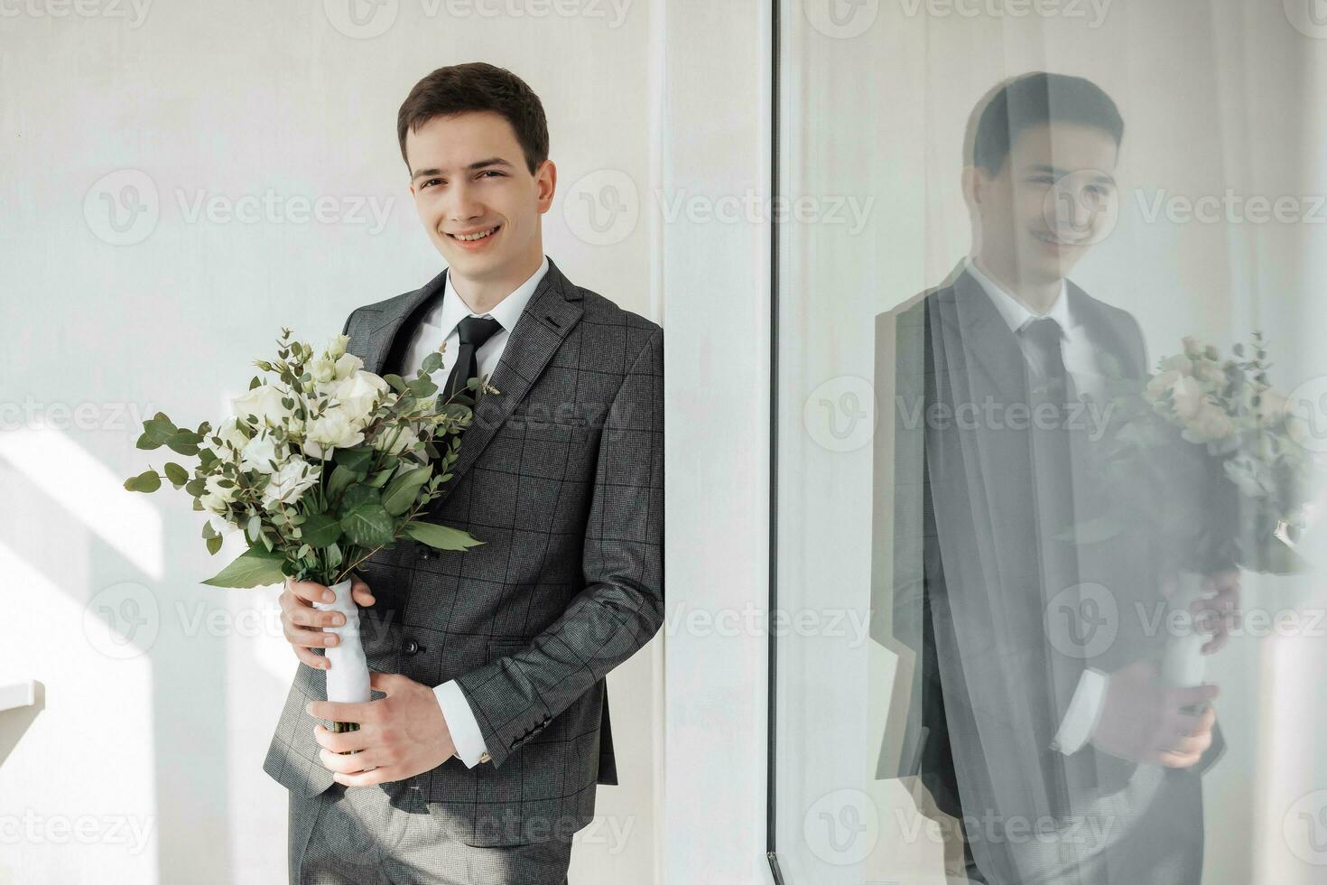de bruidegom, staan, Holding een delicaat bruiloft boeket, glimlachen oprecht. mooi zonlicht. bruiloft portret. foto