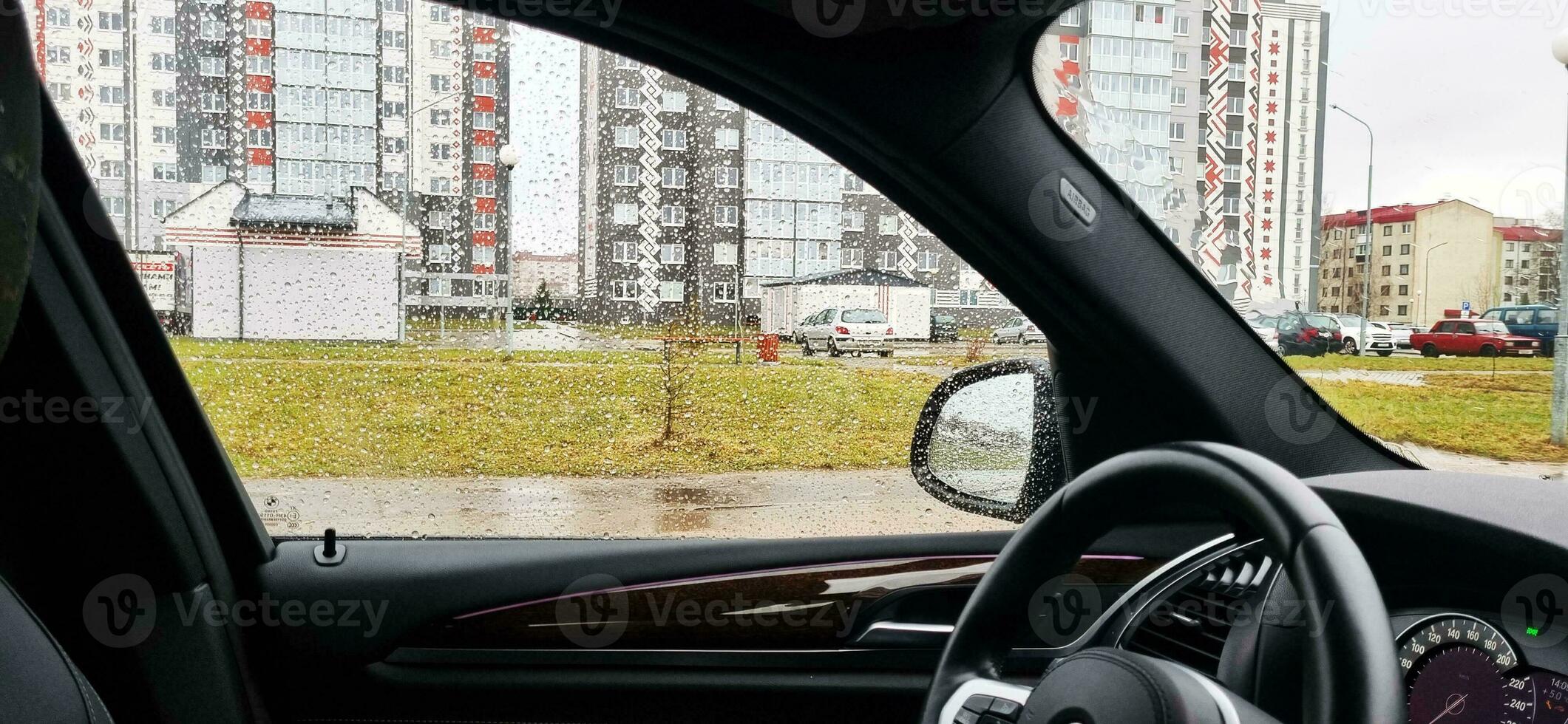 concept schot van de auto venster gedekt door regen druppels. achtergrond foto