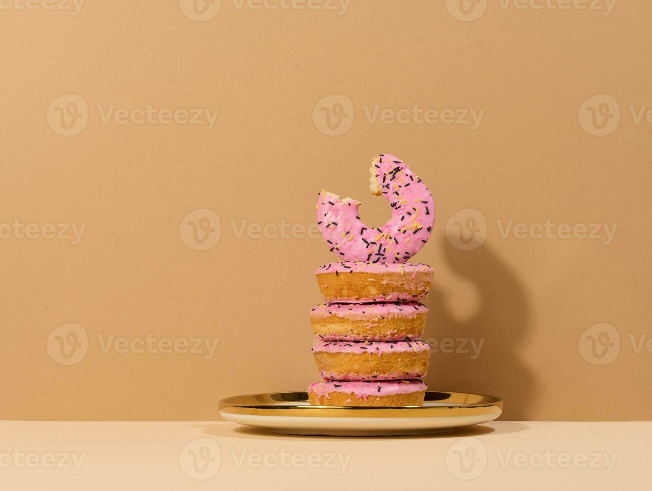 donut gedekt met roze glazuur en besprenkeld met kleurrijk hagelslag Aan een ronde bord foto