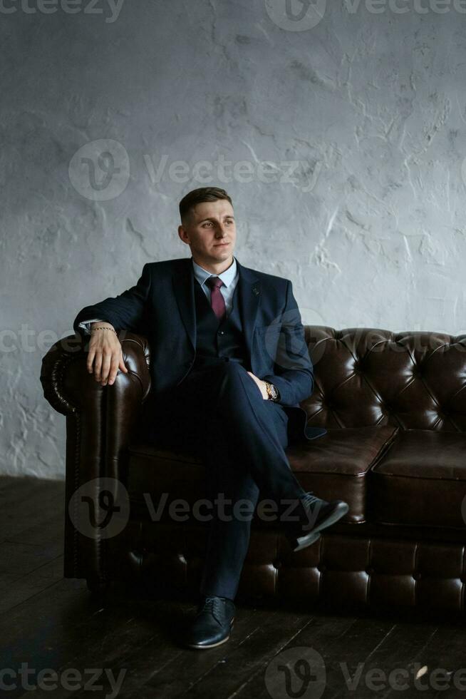 portret van een vrolijk bruidegom in een blauw pak foto