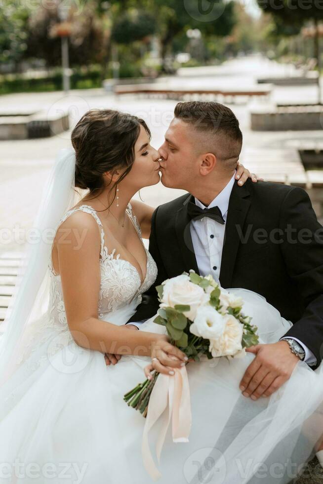 de bruidegom in een bruin pak en de bruid in een witte jurk foto