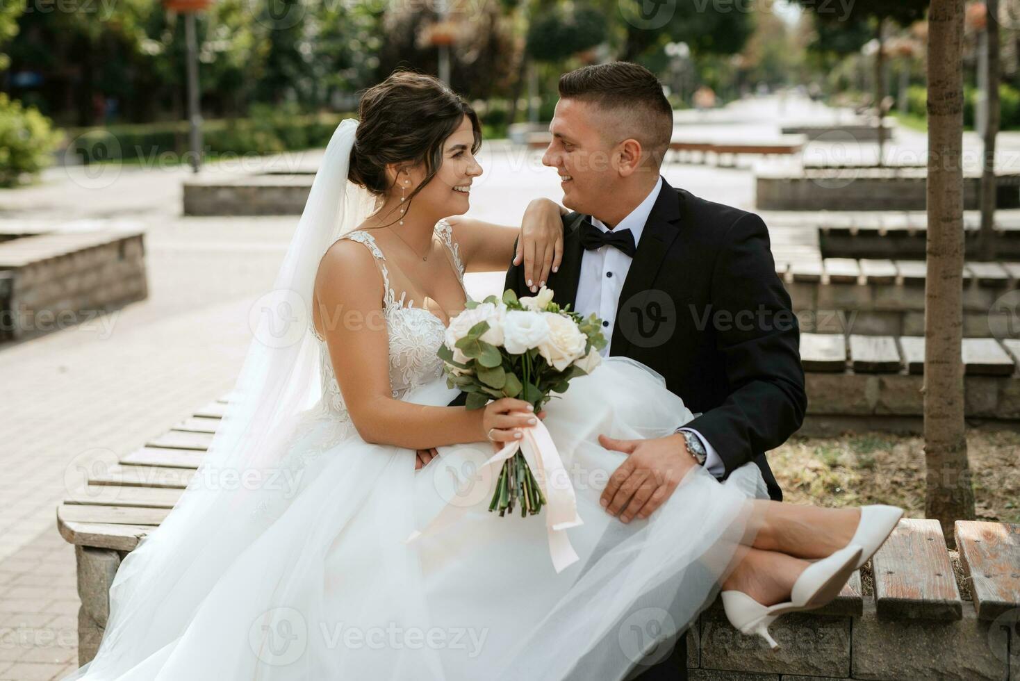 de bruidegom in een bruin pak en de bruid in een witte jurk foto