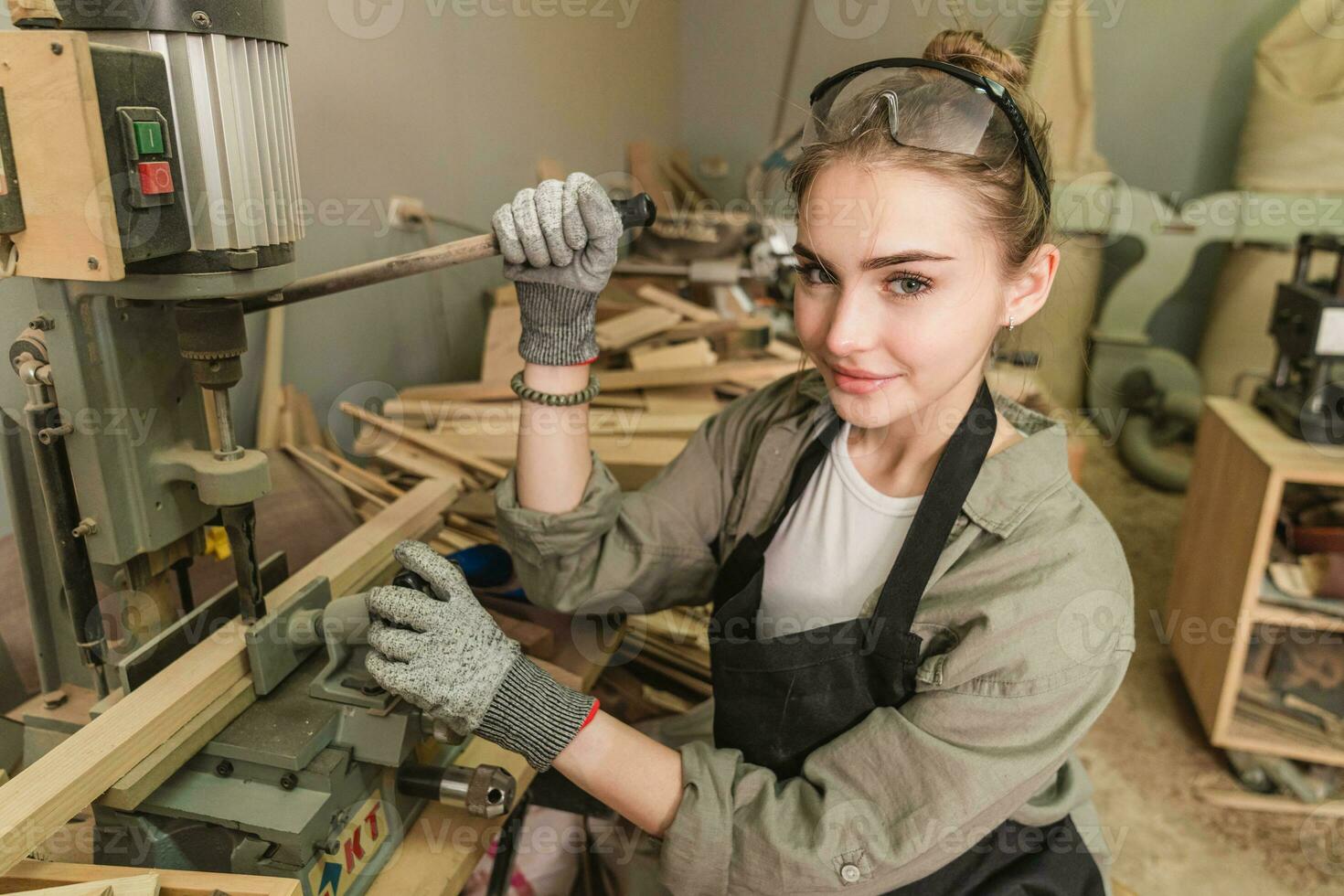 vrouw timmerman vervelend beschermend veiligheid bril en gebruik makend van elektrisch werk Aan een hout. artiest of meubilair ontwerper werken Aan een Product idee in een werkplaats. foto