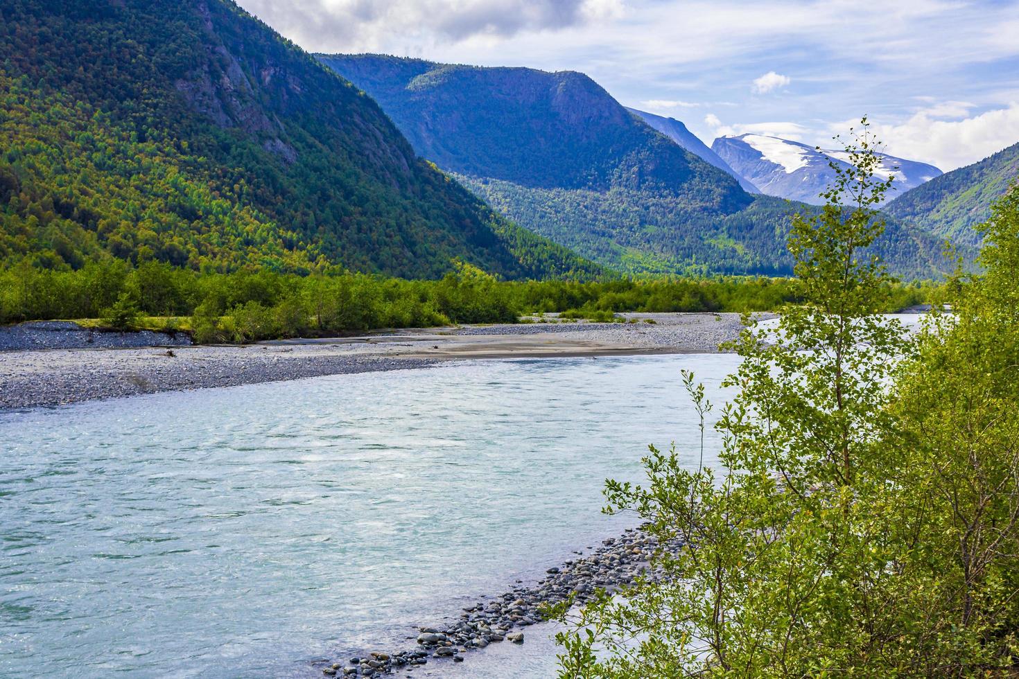 turkoois smeltwater stroomt in een rivier door de bergen van noorwegen foto