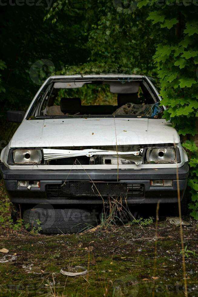 oud vervallen auto in een Woud foto