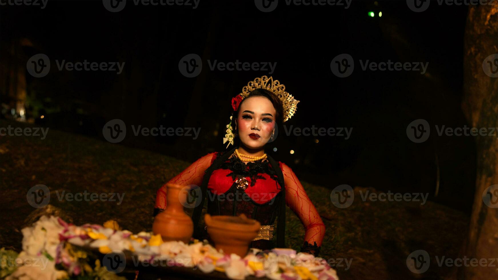 een vrouw danser wie looks mooi in een rood kostuum presteert een ritueel dat straalt uit een aura van schoonheid en zuiverheid foto