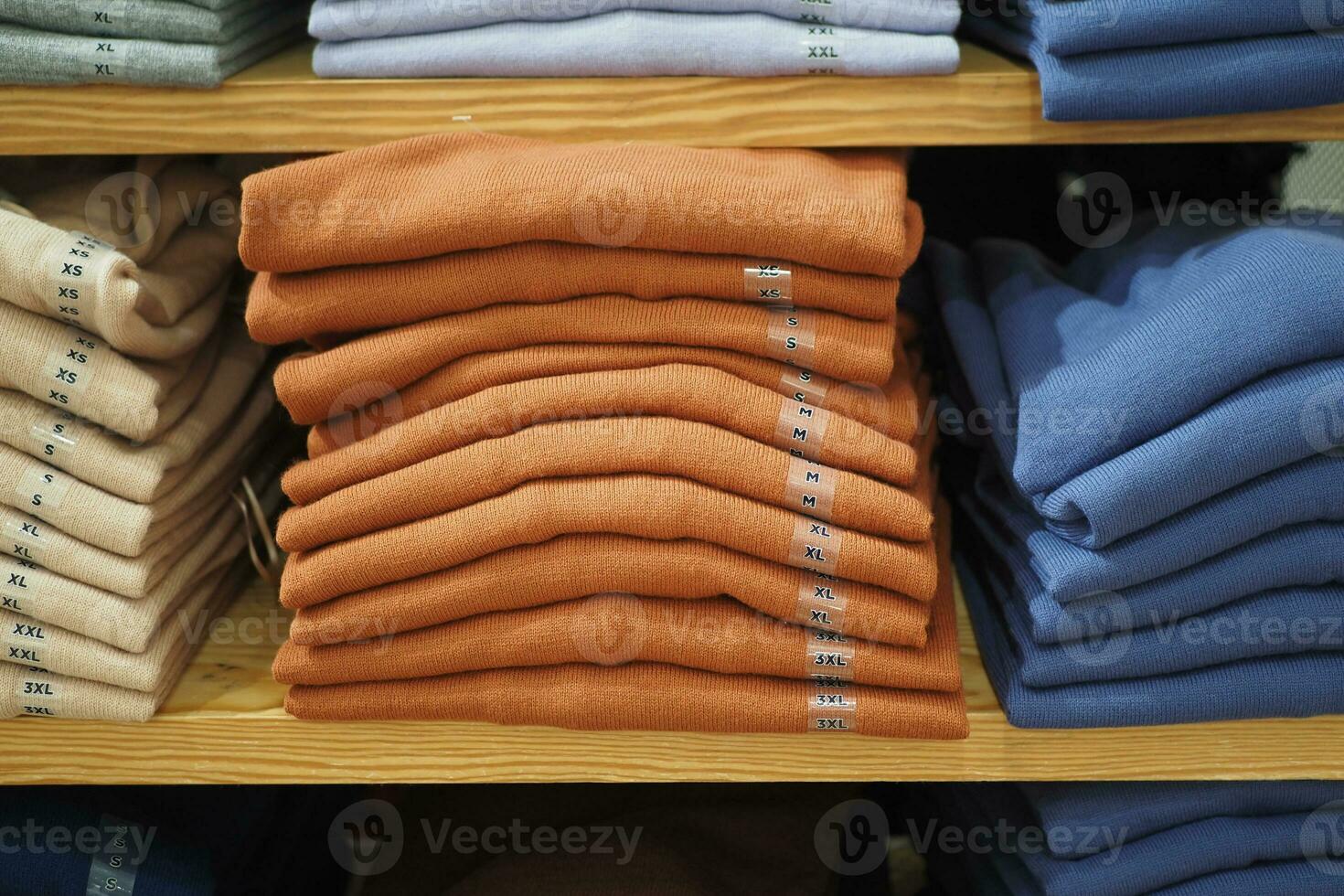 kleurrijk overhemden Aan plank in een kleinhandel winkel foto