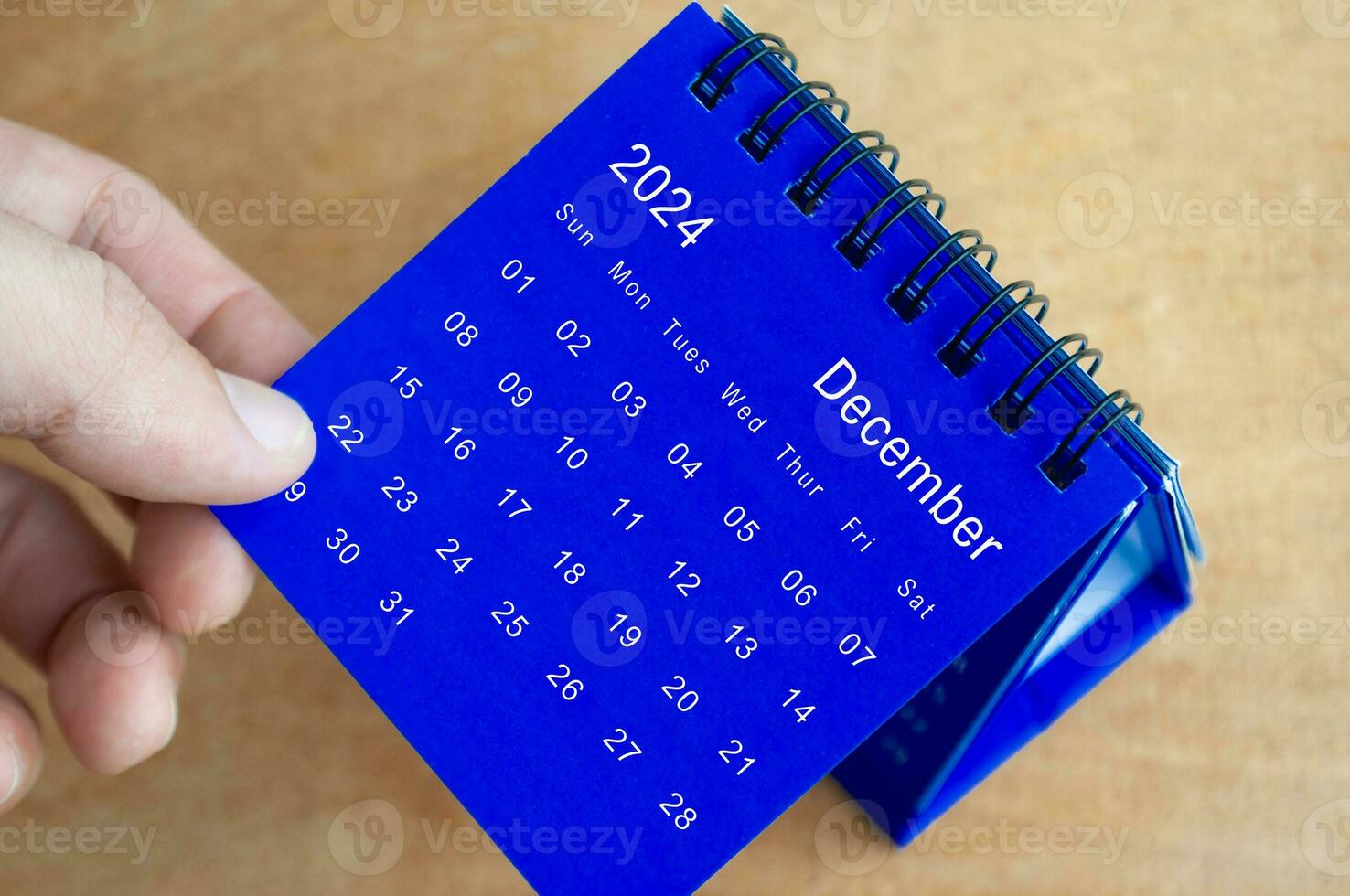 hand- tonen december 2024 tafel kalender Aan houten achtergrond. kalender en nieuw maand concept. foto