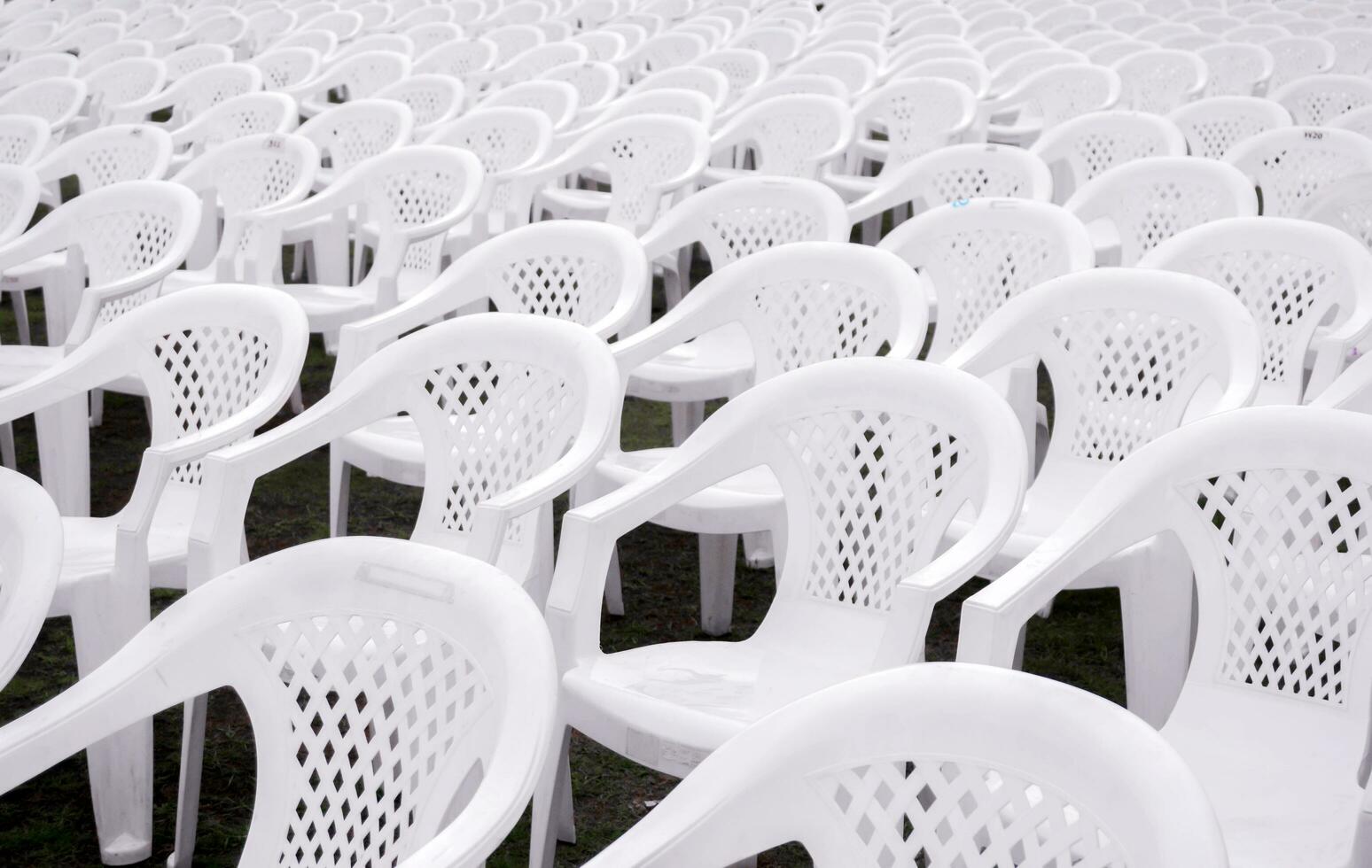 detailopname en Bijsnijden wit plastic stoelen zetten Aan bekleed in rijen voor studenten in de diploma uitreiking ceremonie. foto