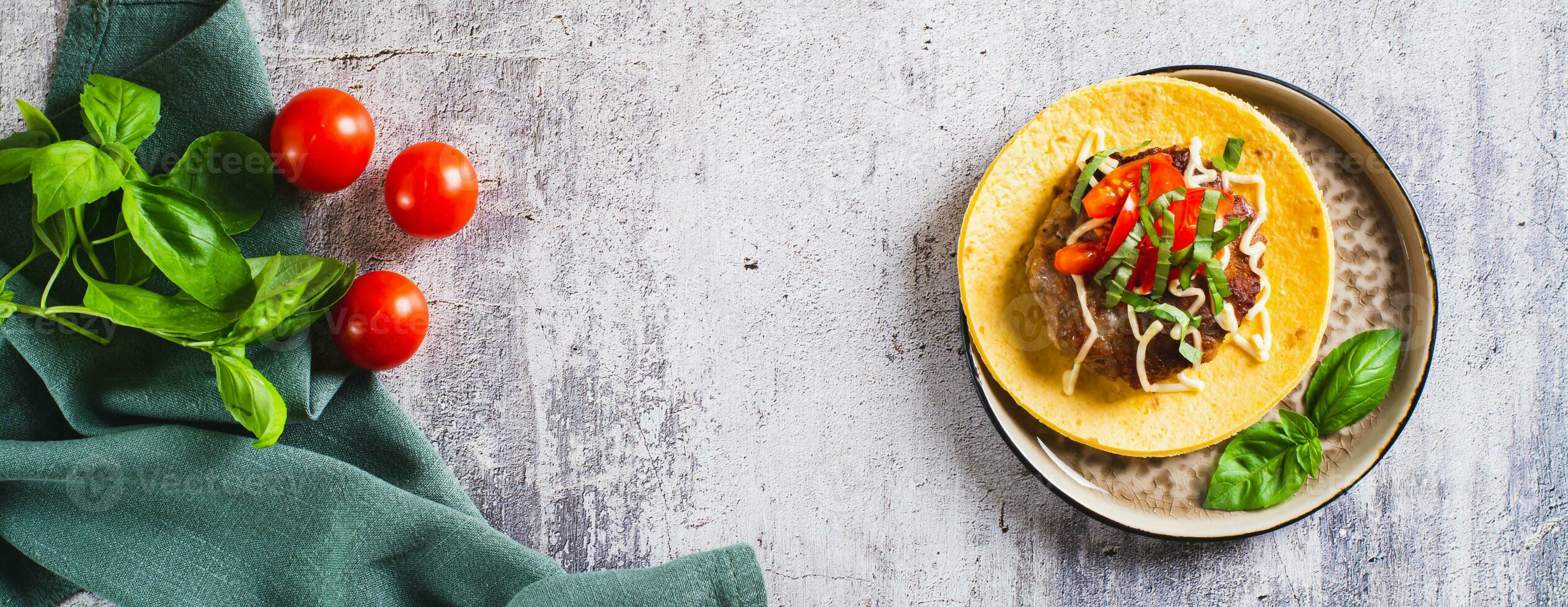 verpletteren hamburger taco's met rundvlees pasteitje, tomaten en basilicum Aan een bord top visie web banier foto