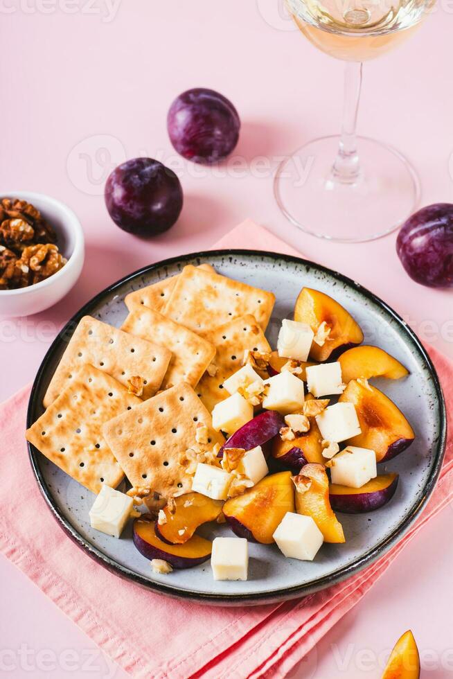 avondeten voor meisjes, koekjes, kaas, pruimen en walnoten Aan een bord Aan de tafel verticaal visie foto