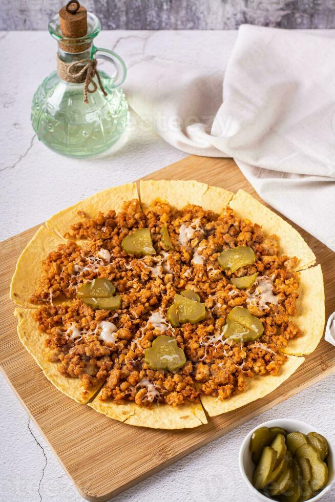 verpletteren hamburger taco's met grond rundvlees Aan tortilla met augurken en kaas Aan bord verticaal visie foto