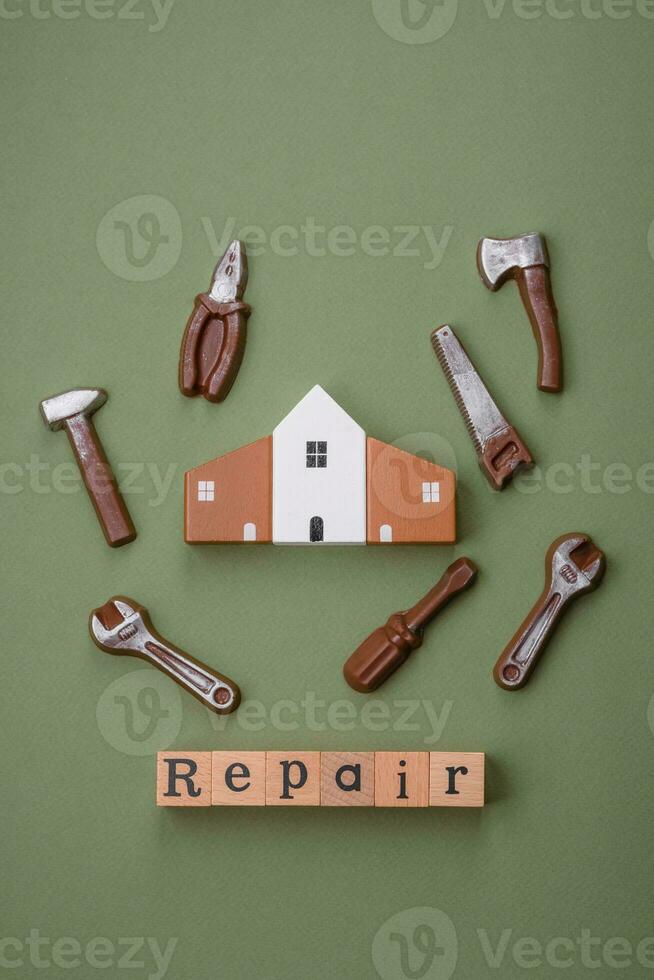 reparatie of huis verbetering gereedschap en een huis model- Aan een duidelijk achtergrond foto