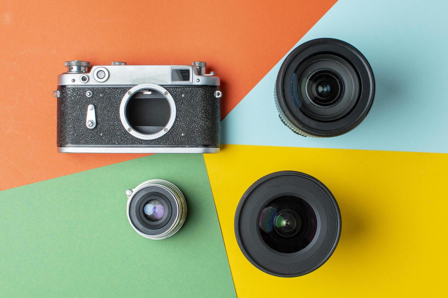 filmcamera met moderne lenzen op een gekleurde achtergrond, digitaal versus film, kleurweergaveconcept foto