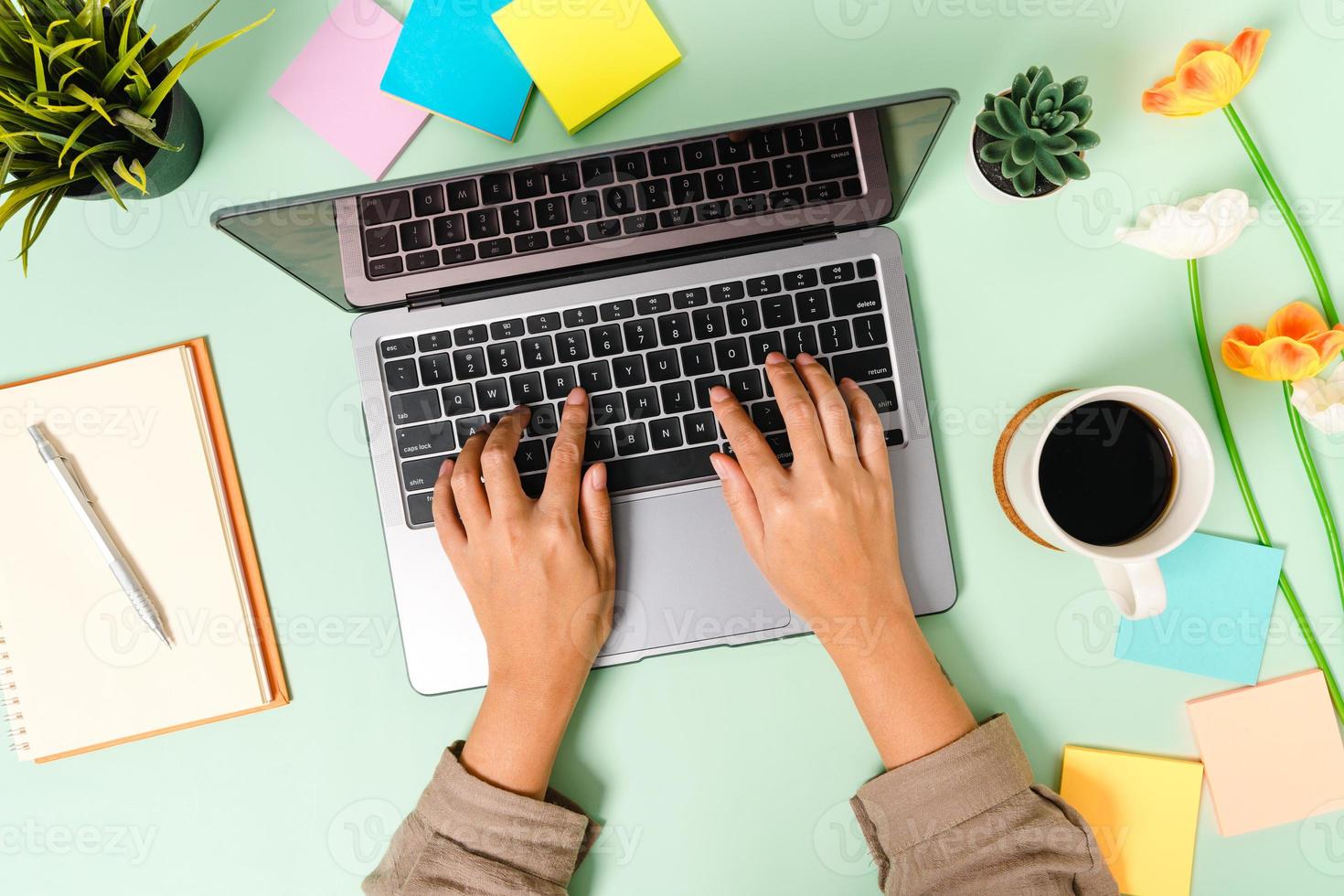 creatieve platliggende foto van een werkruimtebureau. bovenaanzicht bureau met laptop, koffiekopje en open mockup zwarte notebook op pastel groene kleur achtergrond. bovenaanzicht mock-up met kopieerruimtefotografie.