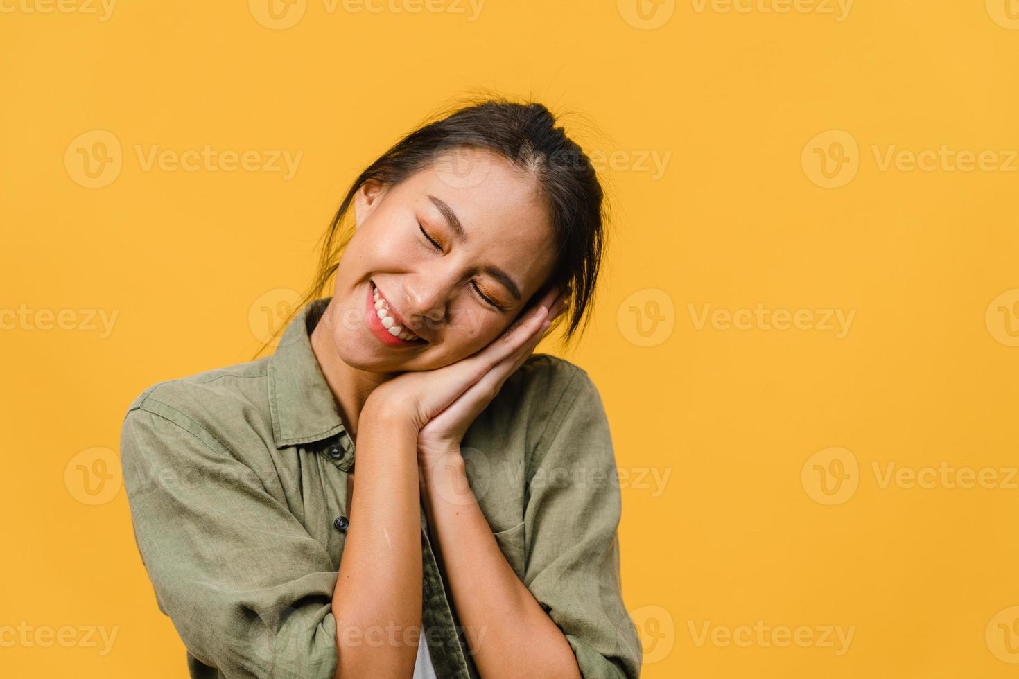 portret van jonge Aziatische dame met positieve uitdrukking, breed glimlachen, gekleed in casual kleding op gele achtergrond. gelukkige schattige blije vrouw verheugt zich over succes. gezichtsuitdrukking concept. foto