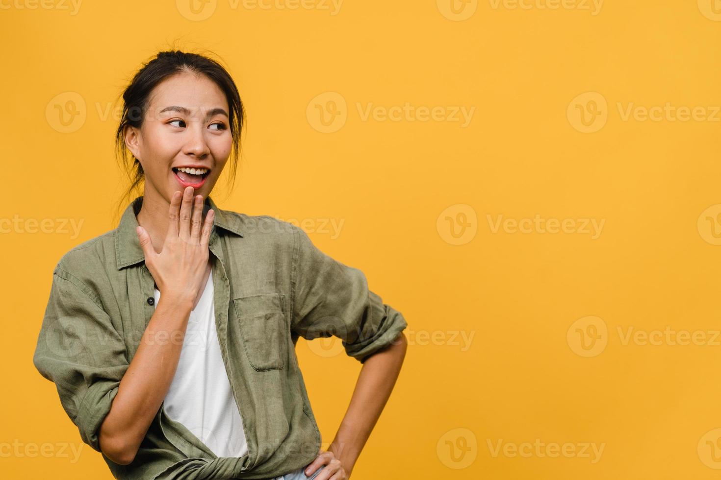 portret van jonge Aziatische dame met positieve uitdrukking, breed glimlachen, gekleed in casual kleding op gele achtergrond. gelukkige schattige blije vrouw verheugt zich over succes. gezichtsuitdrukking concept. foto