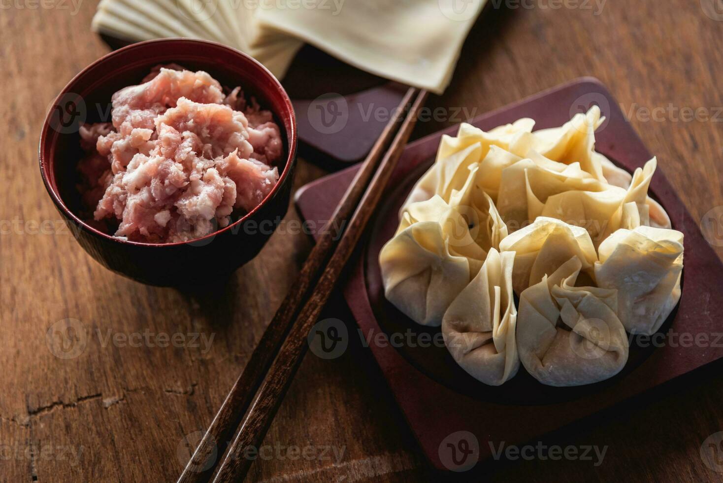 Gesloten omhoog van rauw Chinese knoedel en fijnhakken varkensvlees, ingrediënt voor Koken Aan houten tafel foto