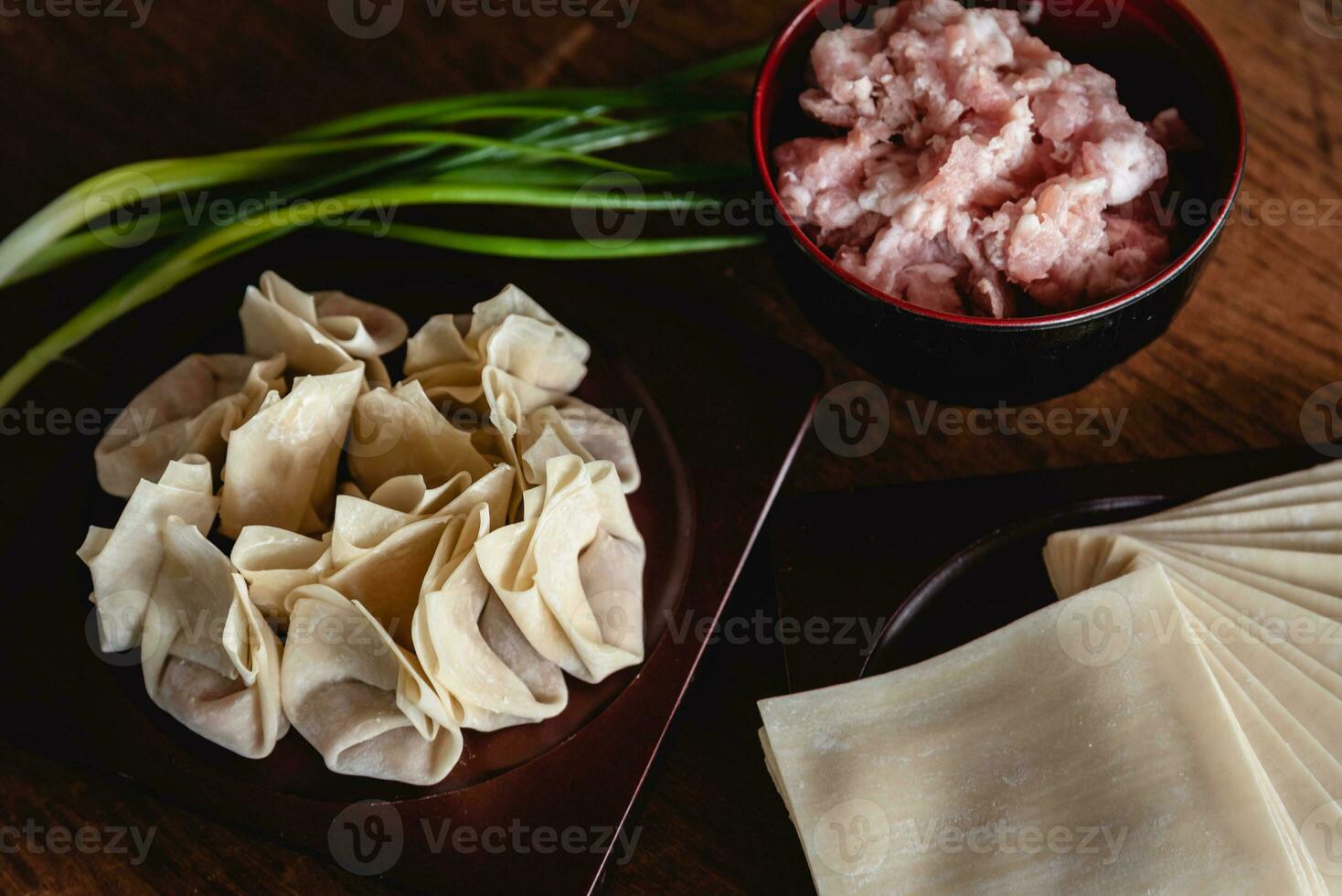 Gesloten omhoog van rauw Chinese knoedel en fijnhakken varkensvlees, ingrediënt voor Koken Aan houten tafel foto