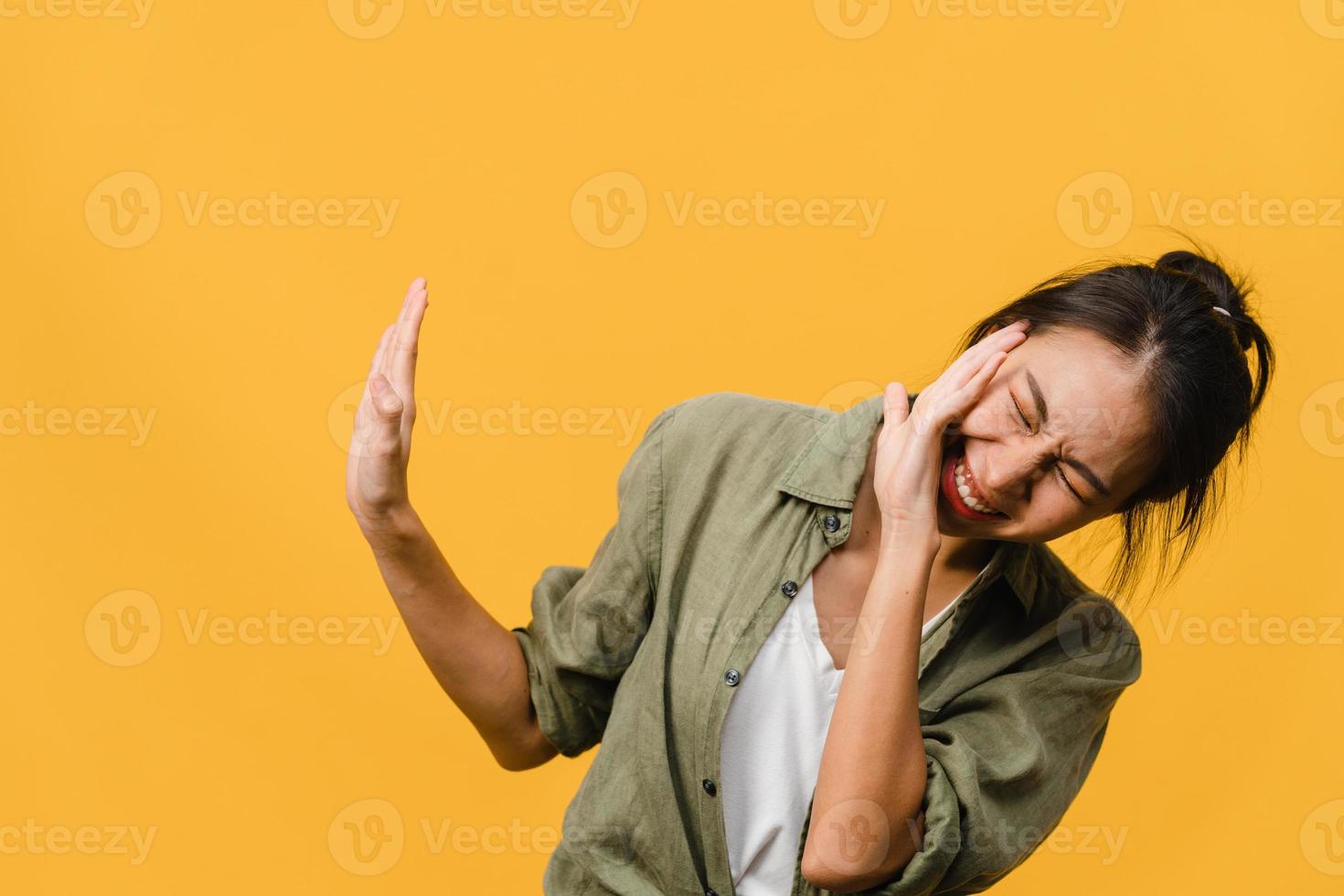 jonge aziatische dame voelt geluk met positieve uitdrukking, vrolijke verrassing funky, gekleed in casual doek geïsoleerd op gele achtergrond. gelukkige schattige blije vrouw verheugt zich over succes. gezichtsuitdrukking. foto