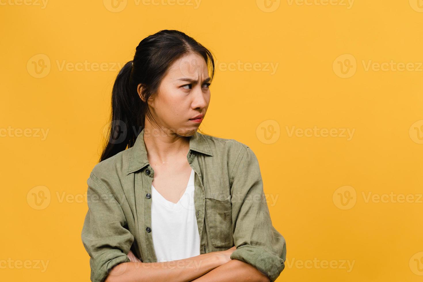 portret van jonge Aziatische dame met negatieve uitdrukking, opgewonden schreeuwen, huilen emotioneel boos in casual kleding geïsoleerd op gele achtergrond met lege kopie ruimte. gezichtsuitdrukking concept. foto