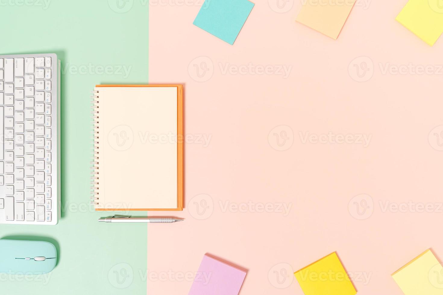 creatieve platliggende foto van een werkruimtebureau. bovenaanzicht bureau met toetsenbord, muis en open mockup zwarte notebook op pastel groen roze kleur achtergrond. bovenaanzicht mock-up met kopieerruimtefotografie.