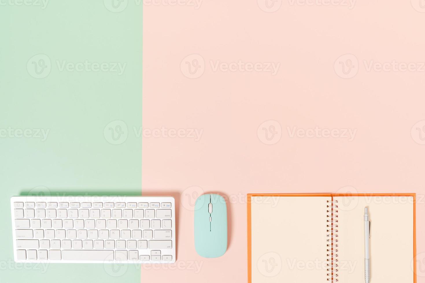 creatieve platliggende foto van een werkruimtebureau. bovenaanzicht bureau met toetsenbord, muis en open mockup zwarte notebook op pastel groen roze kleur achtergrond. bovenaanzicht mock-up met kopieerruimtefotografie.