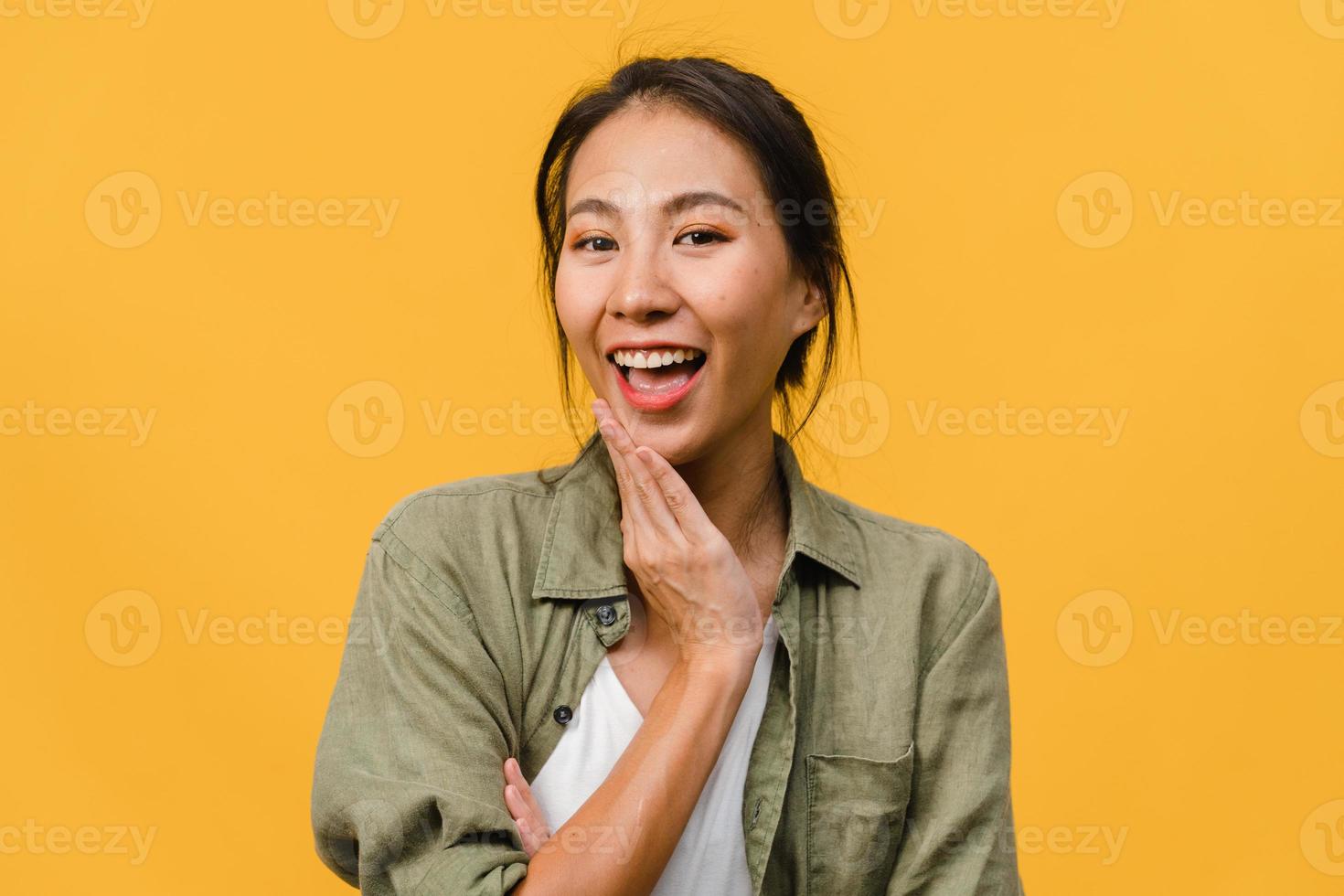 jonge azië dame met positieve uitdrukking, breed glimlachen, gekleed in casual kleding en camera kijken over gele achtergrond. gelukkige schattige blije vrouw verheugt zich over succes. gezichtsuitdrukking concept. foto