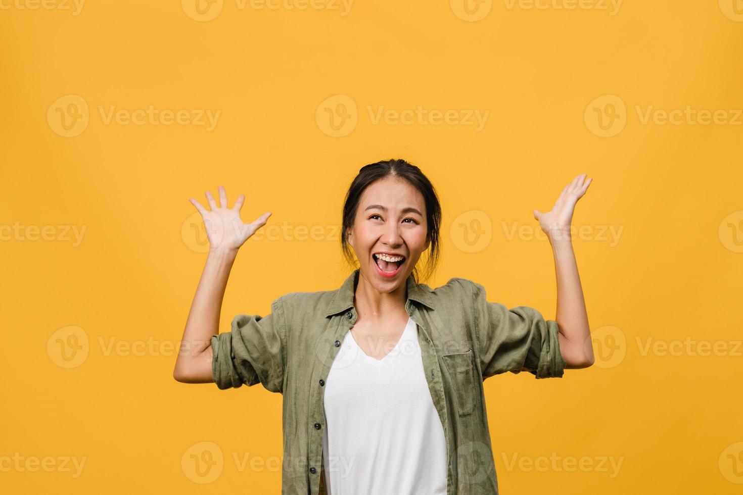 portret van jonge Aziatische dame met positieve uitdrukking, breed glimlachen, gekleed in casual kleding op gele achtergrond. gelukkige schattige blije vrouw verheugt zich over succes. gezichtsuitdrukking concept. foto