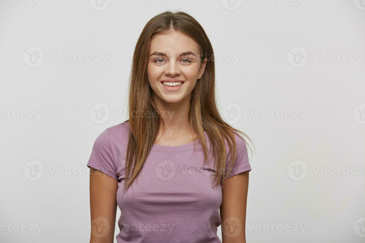 portret van een mooi vrolijk gelukkig jong meisje met natuurlijk bedenken en goed verzorgd haar, glimlacht, draagt gewoontjes t shirt, Aan een wit achtergrond in de studio. foto