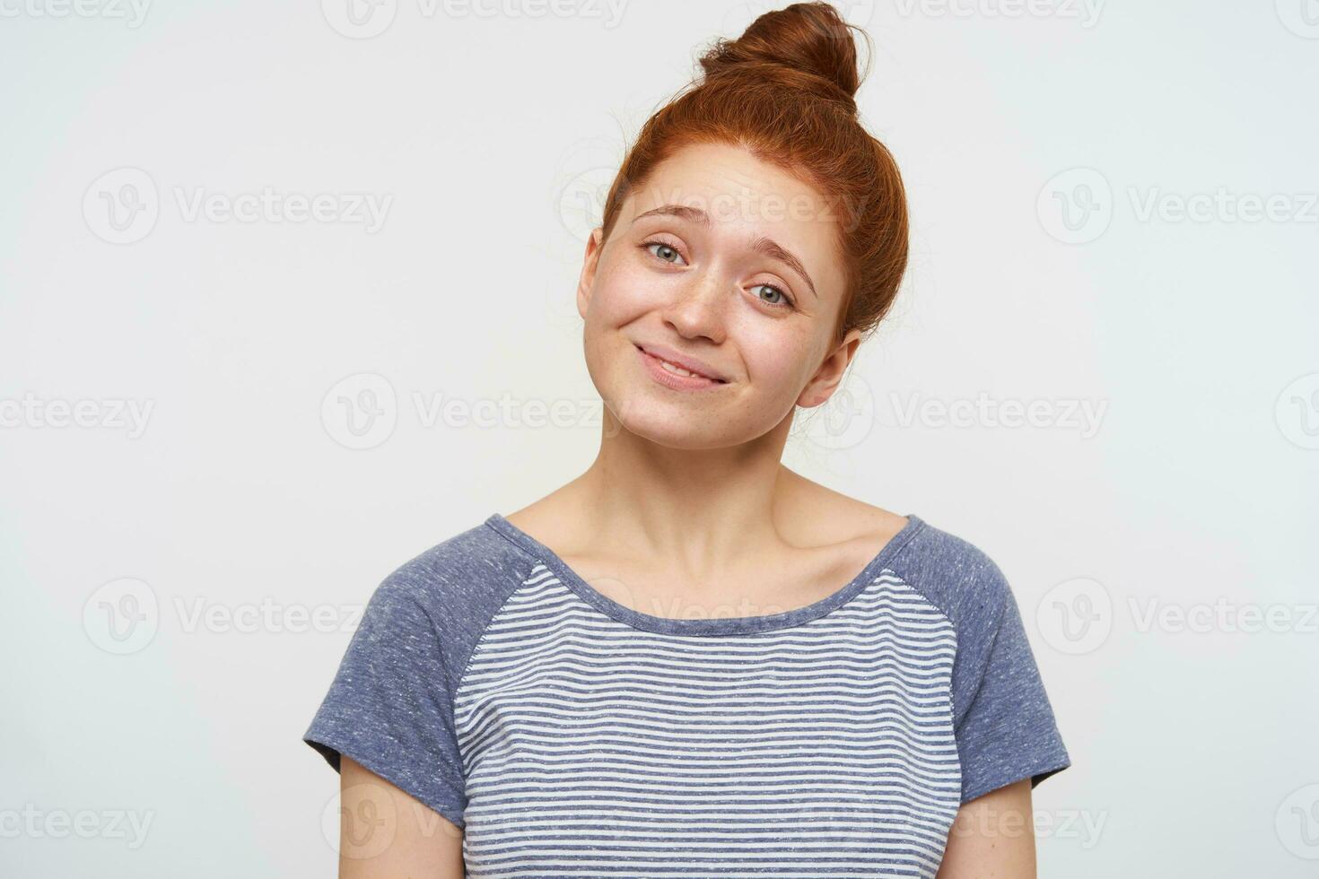 binnen- foto van positief jong groene ogen vrouw vervelend haar foxy haar- in knoop terwijl poseren over- roze achtergrond, houden haar handen naar beneden en glimlachen een beetje Bij camera