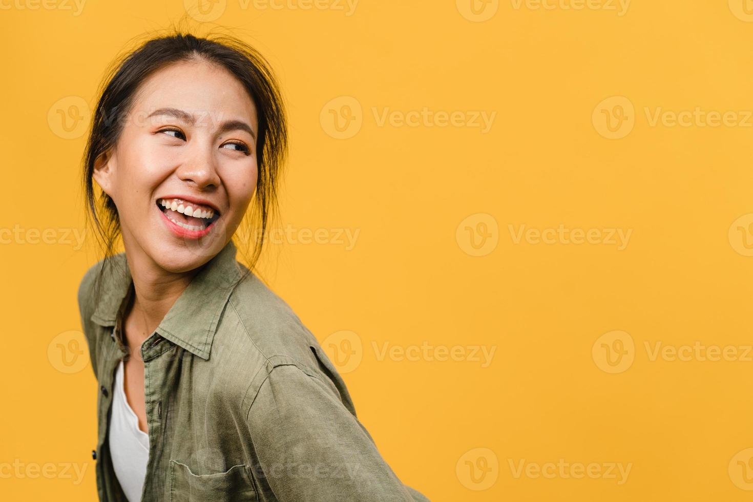 portret van jonge Aziatische dame met positieve uitdrukking, breed glimlachen, gekleed in casual kleding op gele achtergrond. gelukkige schattige blije vrouw verheugt zich over succes. gezichtsuitdrukking concept. foto