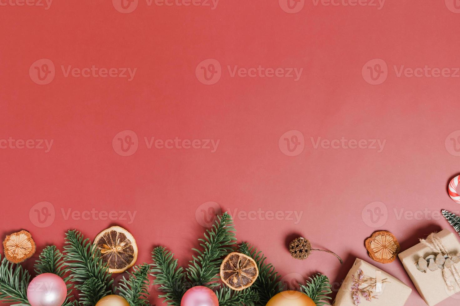 minimale creatieve platte lay van traditionele kerstcompositie en nieuwjaarsvakantieseizoen. bovenaanzicht winter kerstversiering op rode achtergrond met lege ruimte voor tekst. kopieer ruimtefotografie. foto