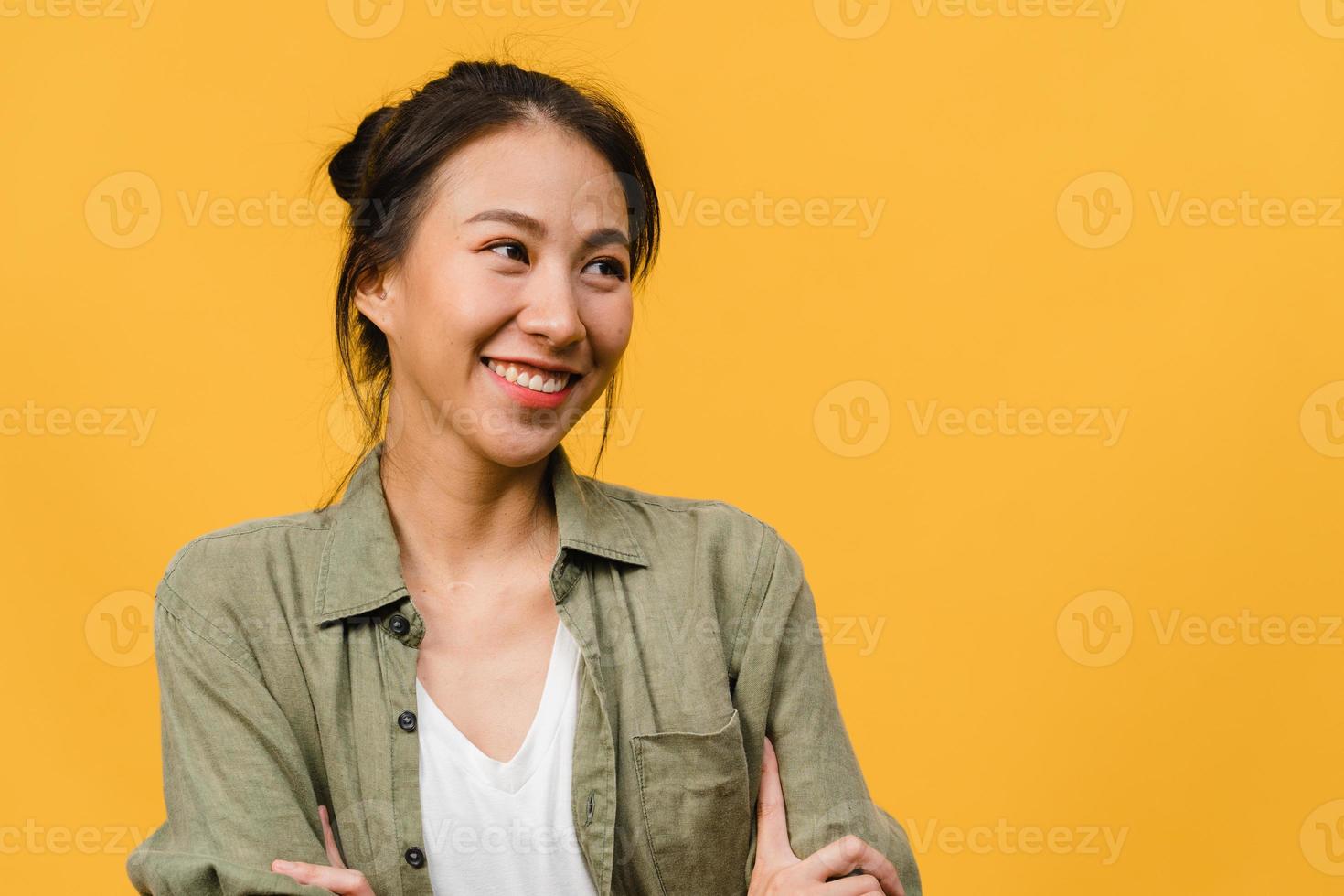 portret van jonge Aziatische dame met positieve uitdrukking, arm gekruist, breed glimlachen, gekleed in casual doek over gele achtergrond. gelukkige schattige blije vrouw verheugt zich over succes. gezichtsuitdrukking concept. foto