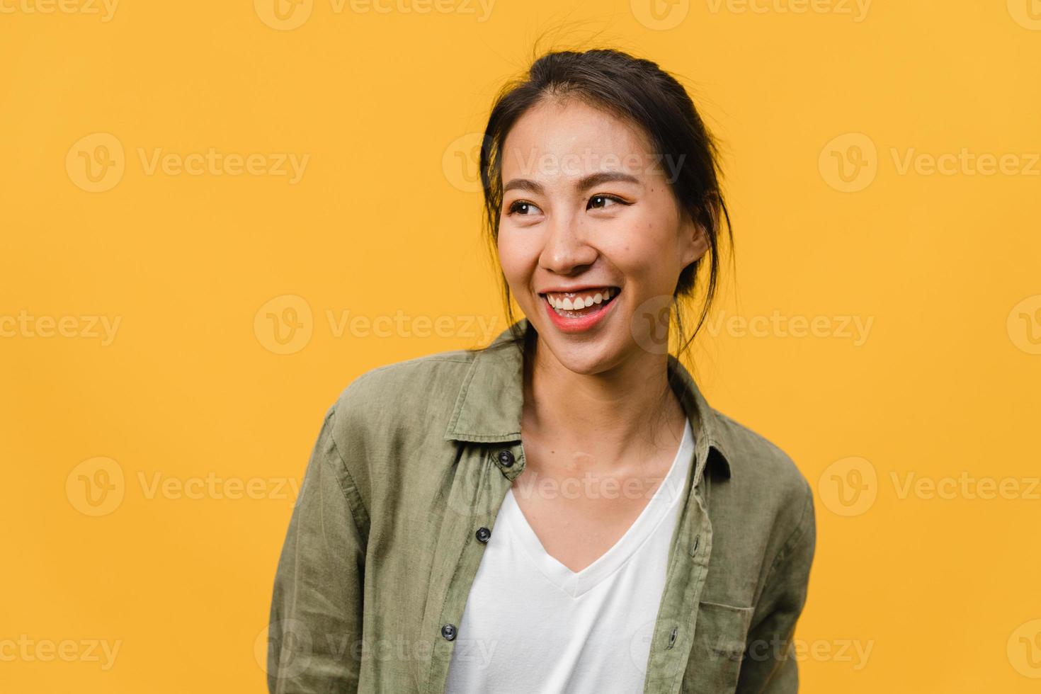 portret van jonge Aziatische dame met positieve uitdrukking, breed glimlachen, gekleed in casual kleding op gele achtergrond. gelukkige schattige blije vrouw verheugt zich over succes. gezichtsuitdrukking concept. foto