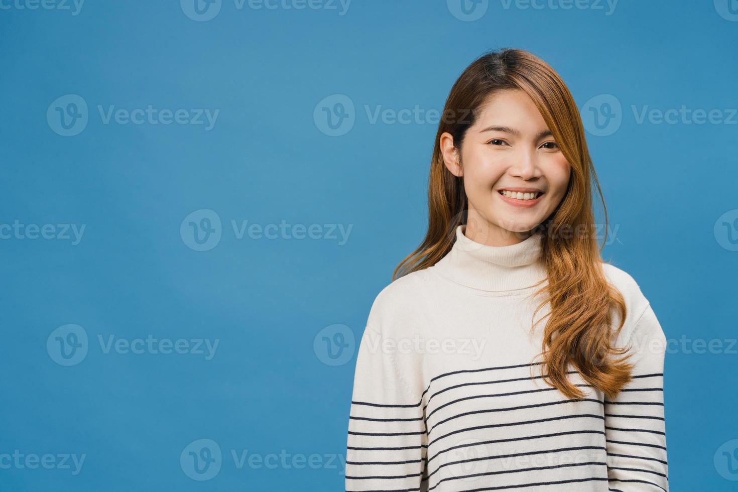 jonge azië dame met positieve uitdrukking, breed glimlachen, gekleed in casual kleding en camera kijken over blauwe achtergrond. gelukkige schattige blije vrouw verheugt zich over succes. gezichtsuitdrukking concept. foto